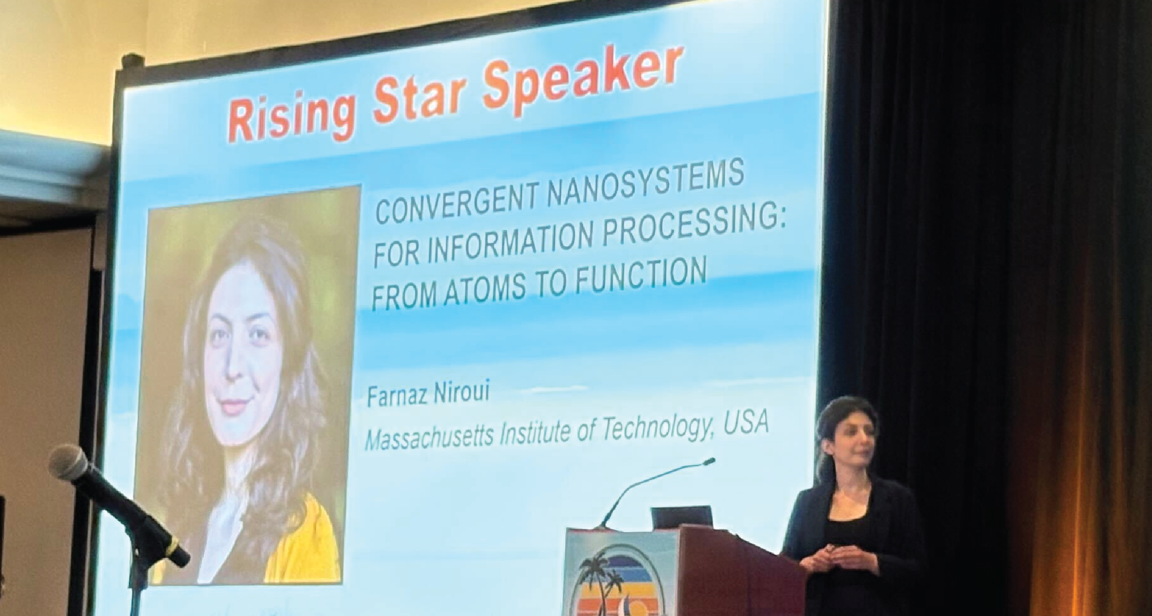 Stage slide announcing a 'Rising Star Speaker' with a portrait of a woman and text about convergent nanosystems for information processing; speaker at podium on right.